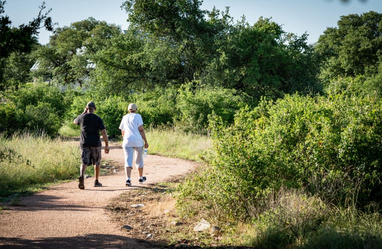 A couple walking down a dirt trail at Vintage Oaks