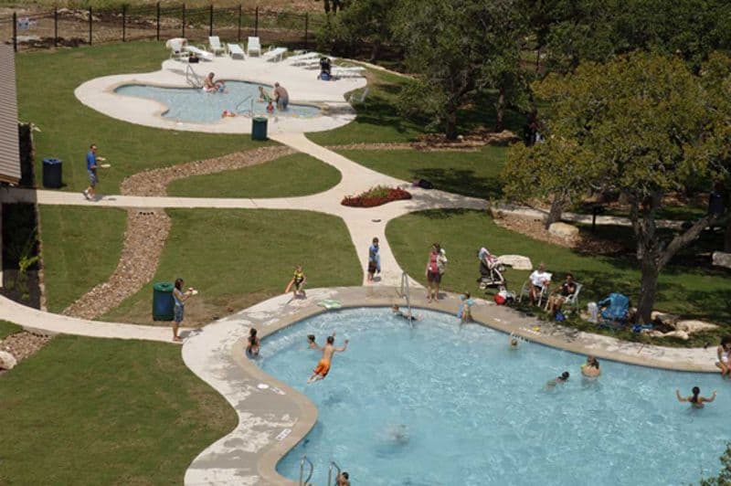 An aerial view of a swimming pool with people in it.
