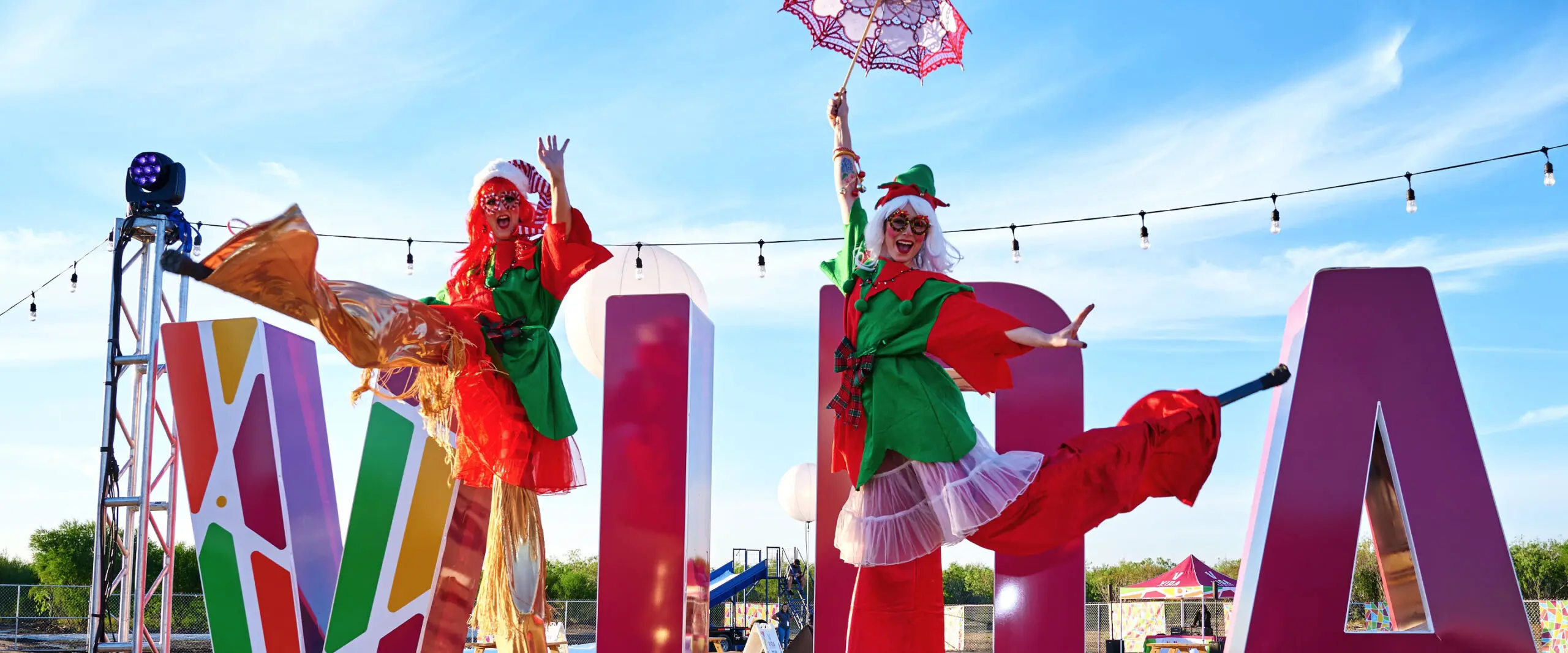 A group of people in costumes are performing in front of a sign.