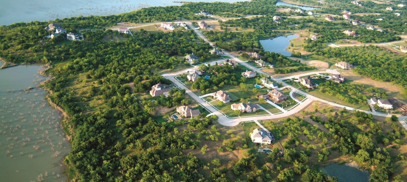 An aerial view of a residential area near a body of water.