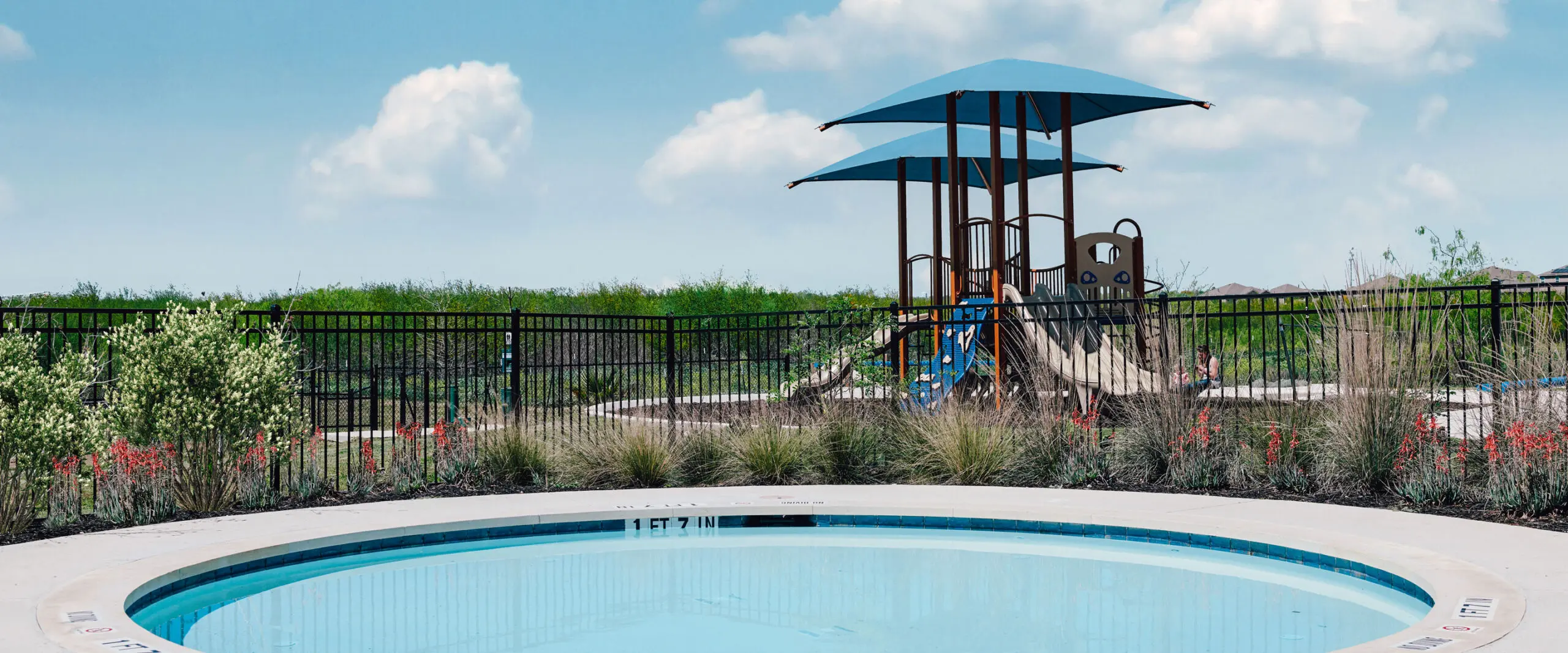 The Mission del Lago swimming pool with a children's playground in the background